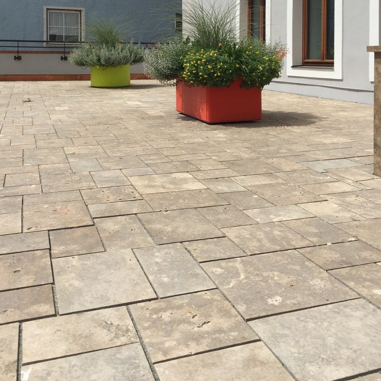 Application image for Bavarian Dolomite Gray Limestone - Pavers. The image shows this product being used in a patio pavers application. Dominant colors shown are gray and tan. The color mix creates a warm feeling.