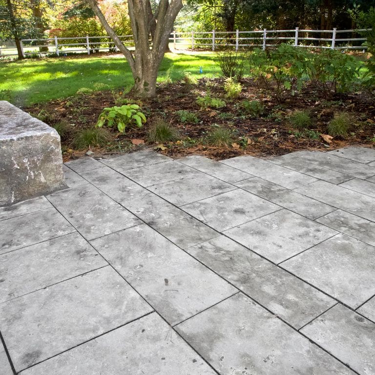 Application image for Bavarian Dolomite - Gray - Pavers. The image shows this product being used in a patio pavers application. The surface finish shown is sand blasted. Dominant colors shown are beige, gray and white. The color mix creates a cool feeling. Random color pattern. Contains voids.