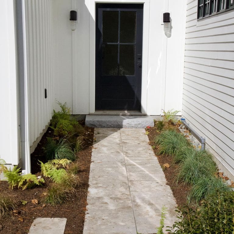 Application image for Bavarian Dolomite - Gray - Pavers. The image shows this product being used in a path pavers application. The surface finish shown is sand blasted. The dominant color shown is gray; with beige, black, brown, orange/rust, white, tan and cream secondaries. The color mix creates a warm feeling. Random color pattern. Contains mineral inclusions.