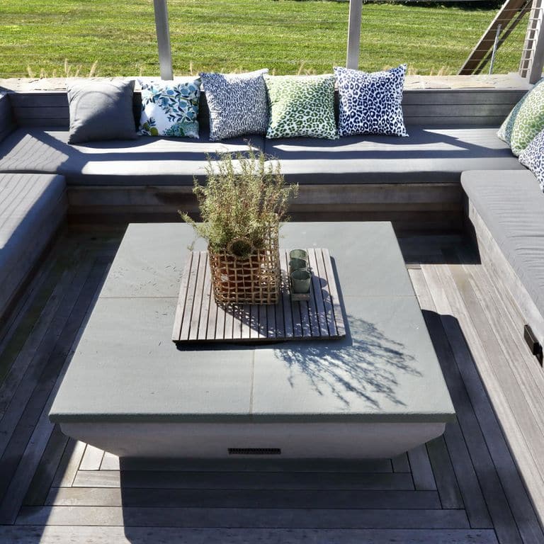 Feature image for Bluestone Flamed Surface Blue/Gray Fire Feature. The image shows this product being used in an outdoor fire concepts application. The surface finish shown is flamed. The dominant color shown is gray. The color mix creates a cool feeling. Solid color pattern.