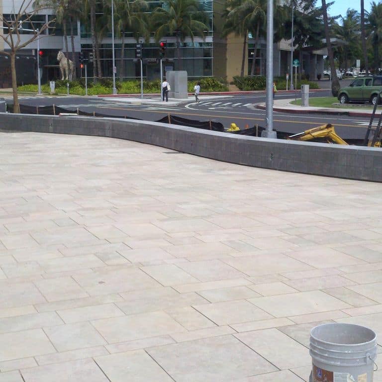 Feature image for Limestone - Cenia Beige - Pool Deck Pavers. The image shows this product being used in a public area application. The surface finish shown is flamed. Dominant colors shown are beige and white; with gray and cream secondaries. The color mix creates a warm feeling. Regular and random color patterns.