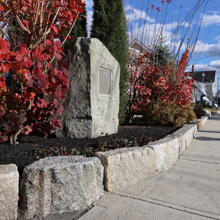 Feature image for Granite - Reclaimed Block - Edging. The image shows this product being used in a landscape curbing &amp; edging application. The dominant color shown is gray.