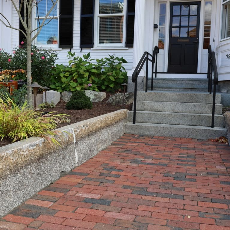 Application image for Granite - Reclaimed Block - Edging. The image shows this product being used in a landscape curbing &amp; edging application. The dominant color shown is gray. The color mix creates a warm feeling.