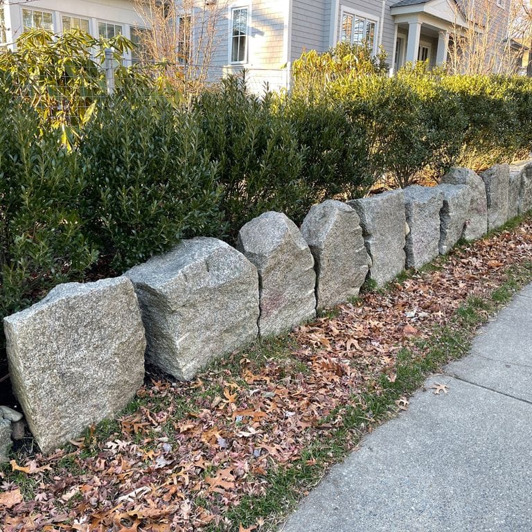 Application image for Granite - Reclaimed Block - Edging. The image shows this product being used in a landscape curbing &amp; edging application. The surface finish shown is . The dominant color shown is gray; with a white secondary. The color mix creates a cool feeling.