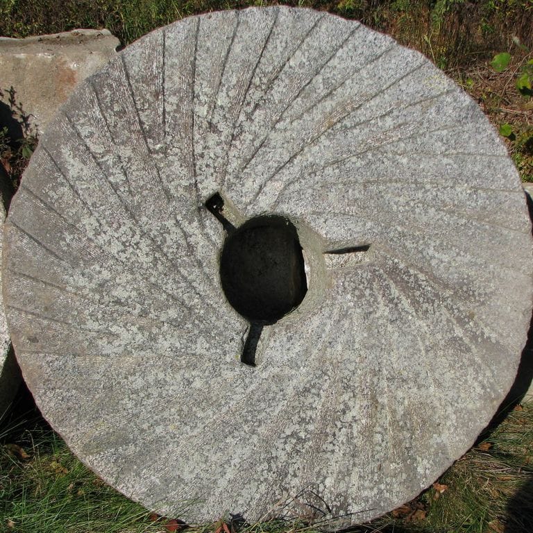Application image for Granite - Reclaimed Antique Mill Stones. The surface finish shown is a combination of carved, chiseled, weathered and worn. The dominant color shown is gray; with beige, green, purple, white and tan secondaries. The color mix creates a cool feeling. Speckled and random color patterns.
