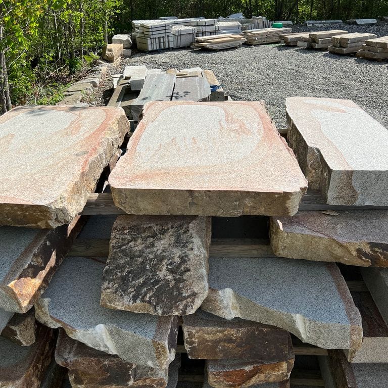 Application image for Granite - Cape Neddick Full Color - Live Edge Steps - Flamed Tops. The surface finish shown is a combination of flamed and natural. Dominant colors shown are beige and cream; with brown, gray, orange/rust, pink, white and tan secondaries. Exhibits "movement" and the color mix creates a warm feeling. Swirled color pattern.