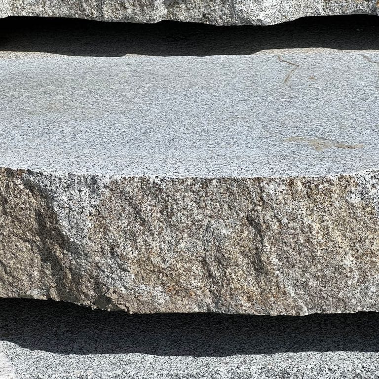 Best close-up image for Granite - Dodlin Hill - Live Edge Steps - Flamed Tops. The surface finish shown is a combination of flamed and natural. The dominant color shown is gray; with beige, black, blue, brown, green, pink, white, tan and cream secondaries. The color mix creates a cool feeling. Speckled color pattern.