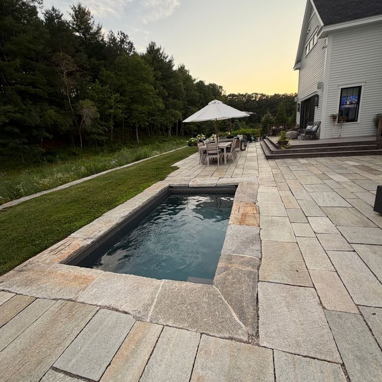 Application image for Pietra Italia Gneiss - Natural Cleft - Pool Deck. The image shows this product being used for patio pavers and pool deck pavers. The surface finish shown is natural cleft. The dominant color shown is gray.