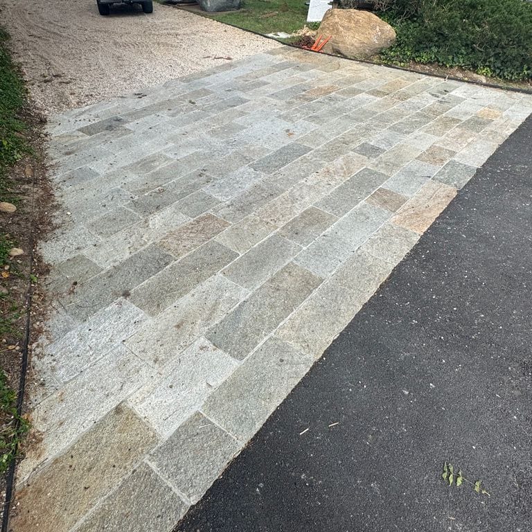 Application image for Pietra Italia Gneiss - Natural Cleft Pavers. The image shows this product being used in a driveway aprons application. The surface finish shown is natural cleft. The dominant color shown is gray. The color mix creates a warm feeling.