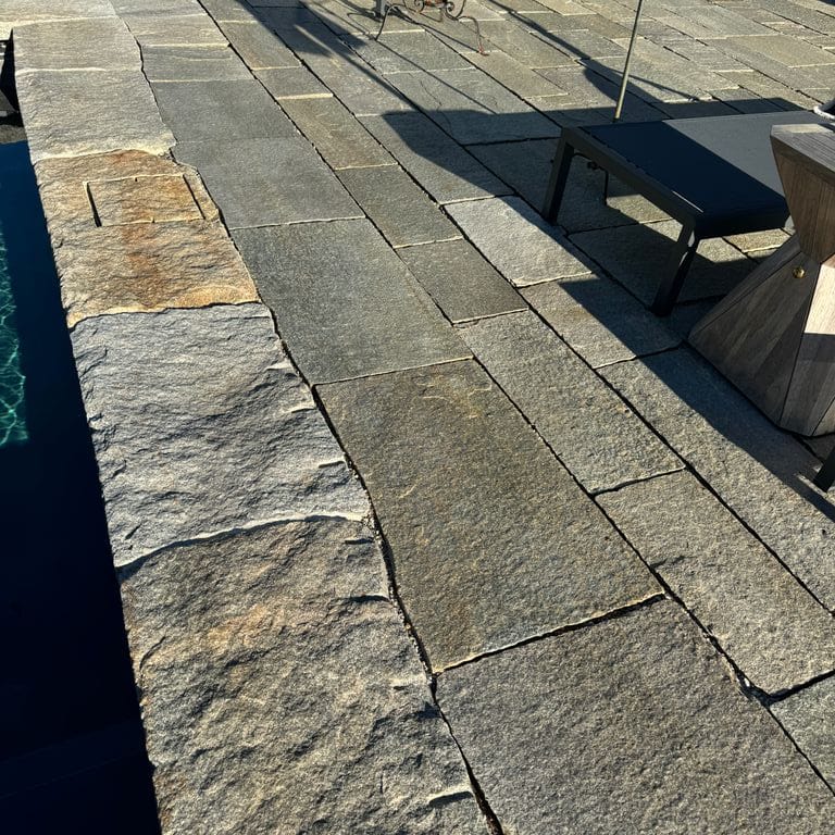Application image for Pietra Italia Full Color Gneiss - Pavers. The image shows this product being used in a pool deck pavers application. The surface finish shown is natural cleft. Dominant colors shown are beige and gray. The color mix creates a warm feeling.