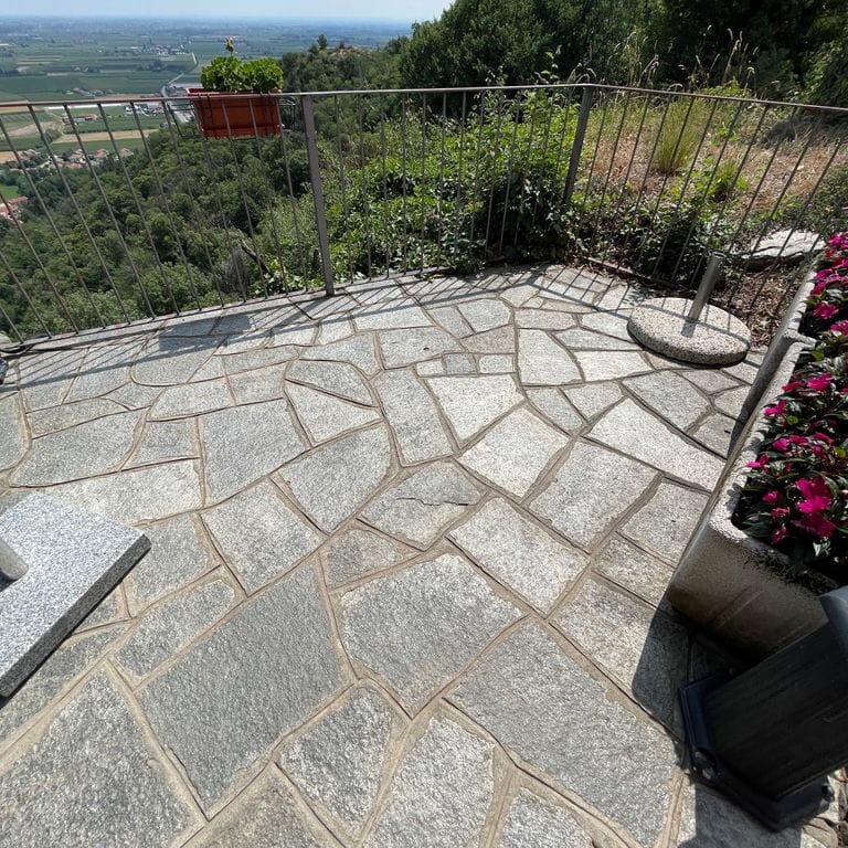Application image for Pietra Italia Full Color Gneiss - Irregular Pavers. The image shows this product being used in a patio pavers application. The surface finish shown is natural cleft. The dominant color shown is gray. The color mix creates a warm feeling.