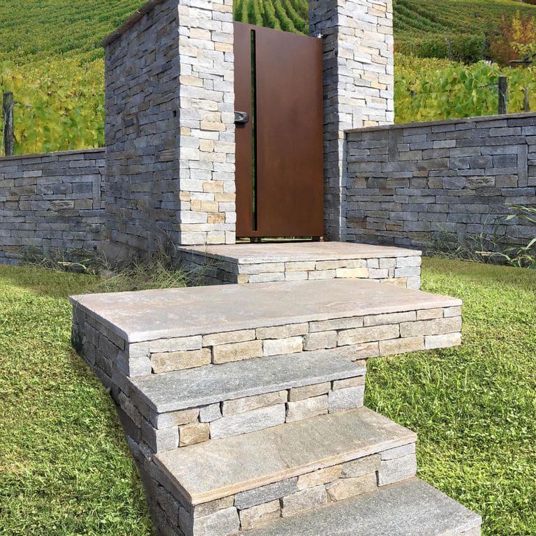 Application image for Pietra Italia Gneiss - Treads. The image shows this product being used in a treads application. The surface finish shown is natural cleft. Dominant colors shown are beige and gray; with brown, green, orange/rust, pink, purple, white, tan and cream secondaries. The color mix creates a warm feeling. Regular, linear and random color patterns. Contains some mica and mineral inclusions.