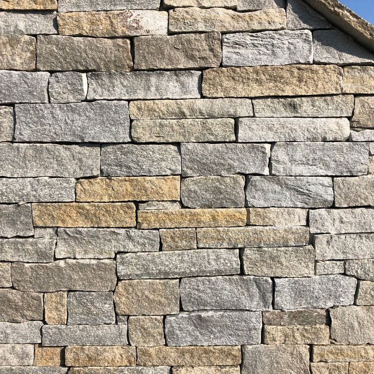 Application image for Pietra Italia Gneiss - Thin Veneer. The image shows this product being used in a thin veneer application. The surface finish shown is natural cleft. Dominant colors shown are gray and tan. The color mix creates a warm feeling.