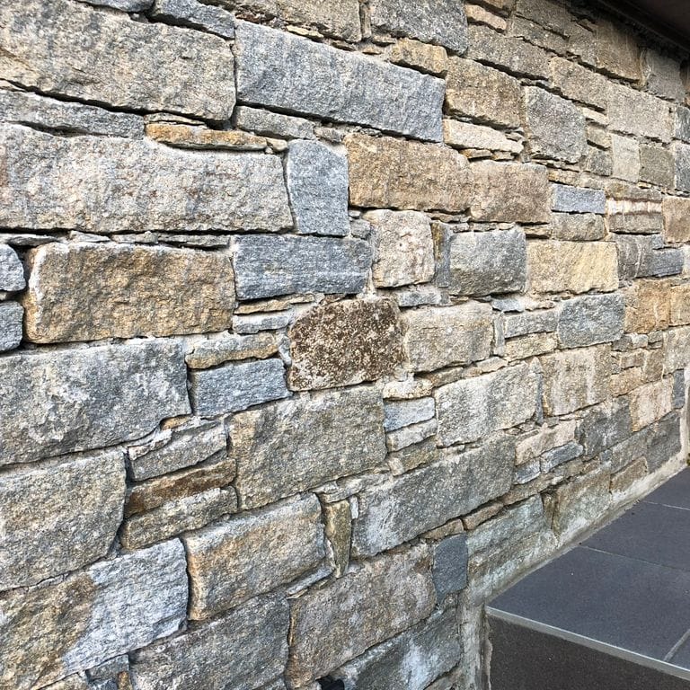 Application image for Pietra Italia Gneiss - Thin Veneer. The image shows this product being used in a thin veneer application. The surface finish shown is natural cleft. Dominant colors shown are gray and tan. The color mix creates a warm feeling.