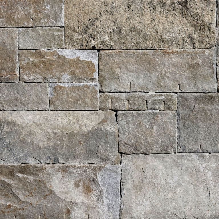 Best close-up image for Reclaimed Granite Curbstone - Full Bed Veneer. The image shows this product being used in a full bed veneer application. The surface finish shown is . Dominant colors shown are gray and tan. Regular and random color patterns.