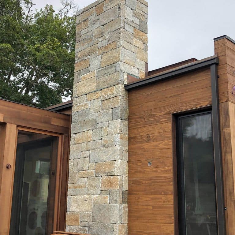 Feature image for Reclaimed Granite Curbstone - Full Bed Veneer. The image shows this product being used in a full bed veneer application. Dominant colors shown are beige, brown and tan. The color mix creates a warm feeling.