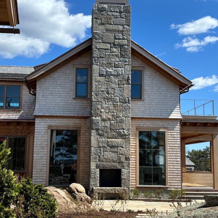Feature image for Reclaimed Granite Curbstone - Full Bed Veneer. The image shows this product being used in a full bed veneer application. The surface finish shown is . The dominant color shown is gray. The color mix creates a cool feeling.