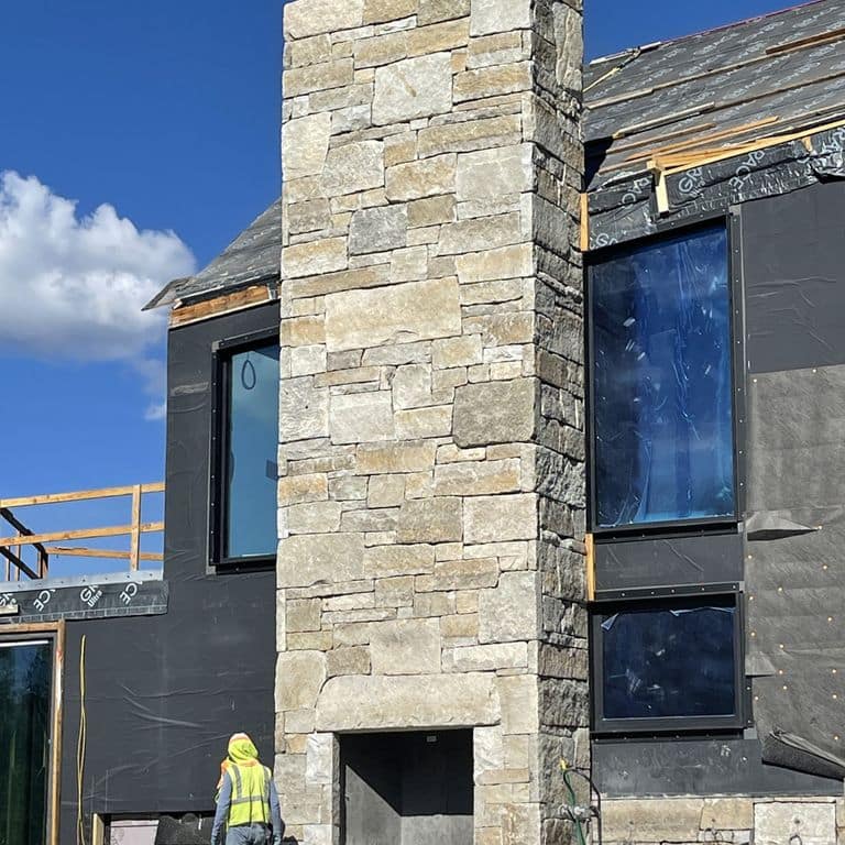 Application image for Reclaimed Granite Curbstone - Full Bed Veneer. The image shows this product being used for outdoor fire concepts and full bed veneer. The surface finish shown is . Dominant colors shown are gray and tan. Regular, speckled and blotched color patterns.