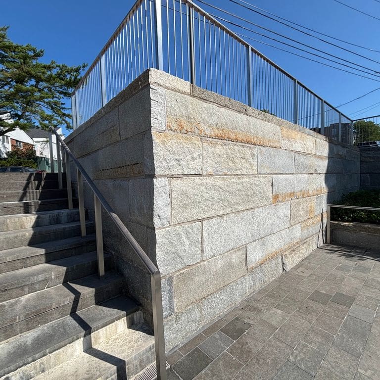 Application image for Reclaimed Granite Curbstone - Plank Veneer. The image shows this product being used in a full bed veneer application. The surface finish shown is . Dominant colors shown are gray and tan. The color mix creates a cool feeling.