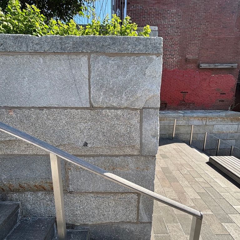 Application image for Reclaimed Granite Curbstone - Plank Veneer. The image shows this product being used in a full bed veneer application. The surface finish shown is . The dominant color shown is gray. The color mix creates a warm feeling.