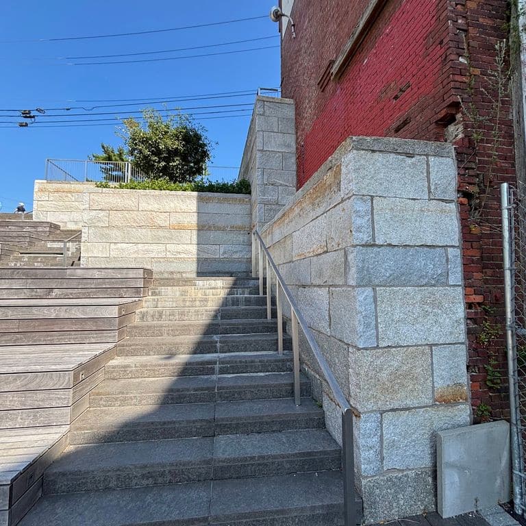 Application image for Reclaimed Granite Curbstone - Plank Veneer. The image shows this product being used in a full bed veneer application. The surface finish shown is . The dominant color shown is gray. The color mix creates a cool feeling.