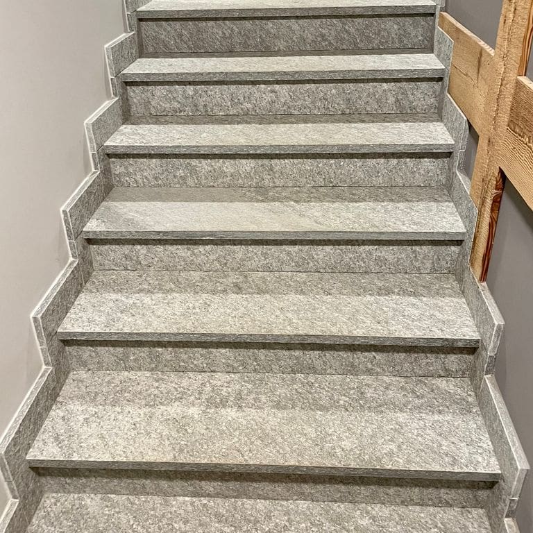 Application image for Pietra Italia Gray Gneiss - Treads. The image shows this product being used in a treads application. The surface finish shown is sand blasted. The dominant color shown is gray. The color mix creates a cool feeling.