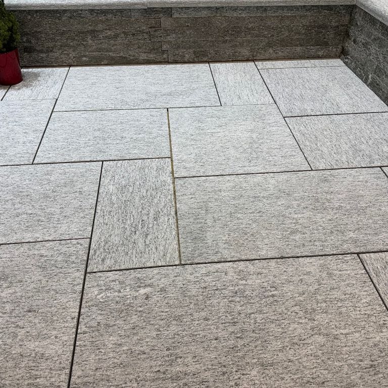 Application image for Pietra Italia Gneiss - Sawn Pavers. The image shows this product being used in a patio pavers application. The surface finish shown is sand blasted. The dominant color shown is gray.
