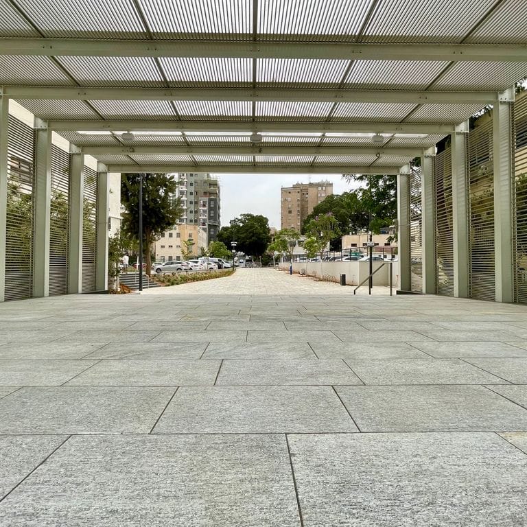 Application image for Pietra Italia Gneiss - Sawn Pavers. The image shows this product being used for path pavers and public area. The surface finish shown is flamed. Dominant colors shown are beige and gray; with brown, green, orange/rust, pink, purple, white, tan and cream secondaries. Regular and cloudy color patterns.
