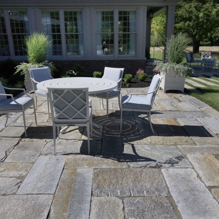 Feature image for Reclaimed Granite Curbstone Plank Paver Mix - Random Widths and Lengths to 36". The image shows this product being used in a patio pavers application. The surface finish shown is . The dominant color shown is gray. Speckled color pattern.