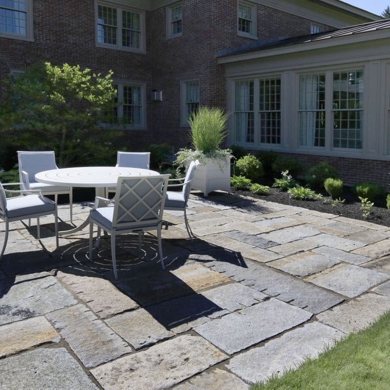 Application image for Reclaimed Granite Curbstone Plank Paver Mix - Random Widths and Lengths to 36". The image shows this product being used in a patio pavers application. The surface finish shown is . The dominant color shown is gray. Speckled color pattern.