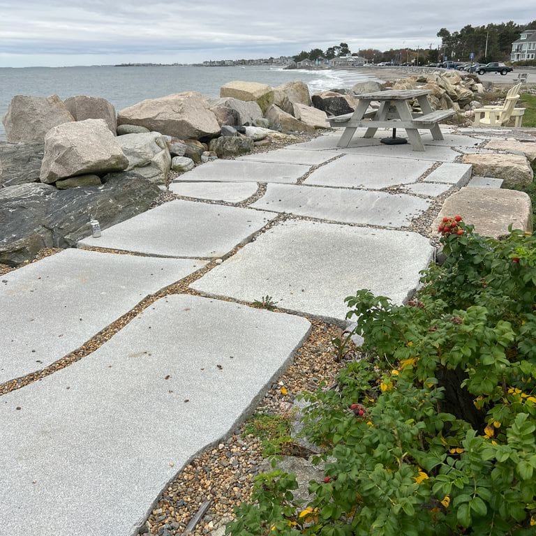 Best close-up image for Granite - Chelmsford Gray - Live Edge Paver. The image shows this product being used in a patio pavers application. The dominant color shown is gray. The color mix creates a warm feeling.