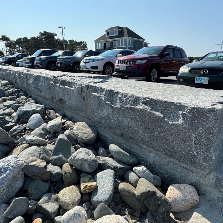 Application image for Granite - Dodlin Hill - Bridge Block. The image shows this product being used in a retaining wall application. The surface finish shown is natural cleft. The dominant color shown is gray. The color mix creates a cool feeling.