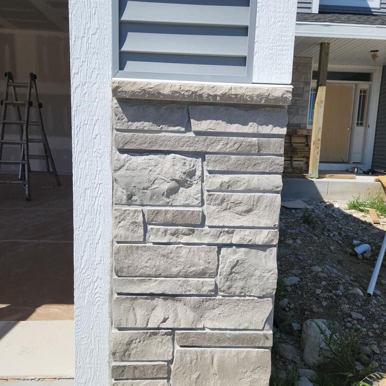 Best close-up image for Lannon Gray Limestone Veneer - Splitface + Sawn. The image shows this product being used in a thin veneer application. The surface finish shown is split-face. The dominant color shown is gray. The color mix creates a cool feeling.