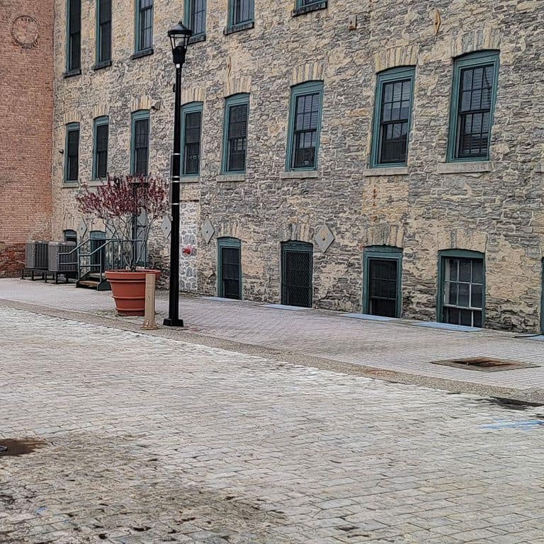 Application image for Limestone - Reclaimed Rochester Pavers. The image shows this product being used for driveway pavers, path pavers, patio pavers and driveway aprons. The surface finish shown is split-face. The dominant color shown is gray.