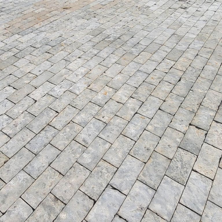 Application image for Limestone - Reclaimed Rochester Pavers. The image shows this product being used for driveway pavers, path pavers, patio pavers and driveway aprons. The surface finish shown is split-face. The dominant color shown is gray. The color mix creates a cool feeling.
