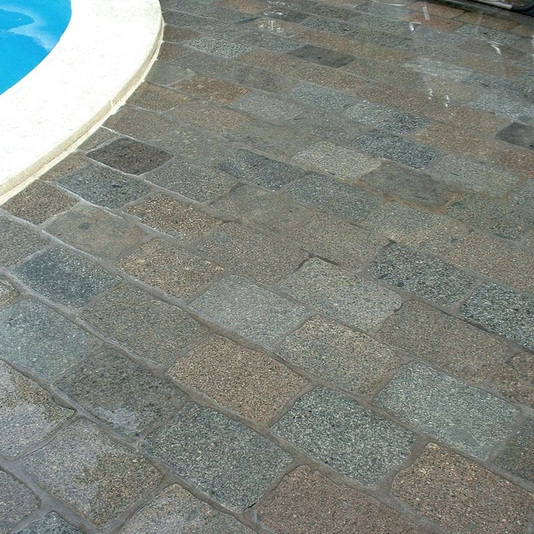 Application image for Porphyry - Reclaimed European Cobblestone - Rectangle - Flat Surface. The image shows this product being used in a patio pavers application. The surface finish shown is sawn. The dominant color shown is gray. The color mix creates a cool feeling.