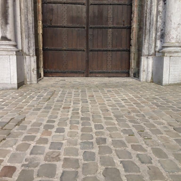 Application image for Sandstone - Reclaimed European Cobblestones - Square - Flat Surface. The image shows this product being used for path pavers and patio pavers. The surface finish shown is sawn. The dominant color shown is gray. The color mix creates a warm feeling.
