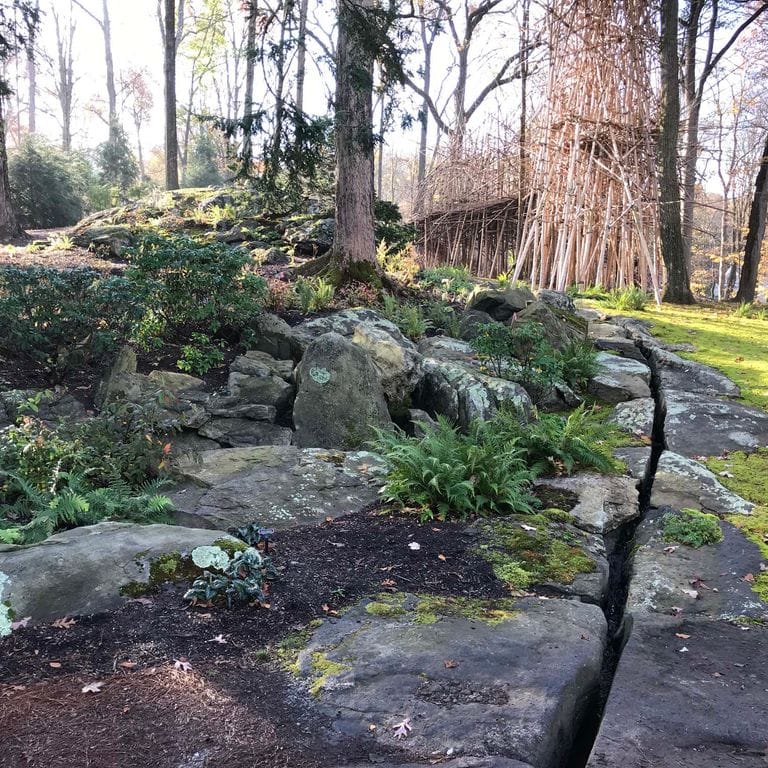 Application image for New England Fieldstone Boulders &amp; Ledgestone - Pool/Pond Coping. The image shows this product being used for water features and landscape boulders &amp; ledge. The surface finish shown is weathered. The dominant color shown is gray. The color mix creates a cool feeling.