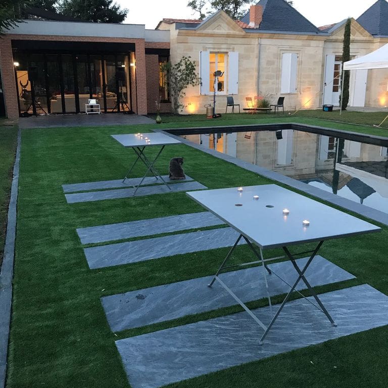 Application image for Slate - Iberian Gray - Pavers. The image shows this product being used in a patio pavers application. The surface finish shown is flamed. The dominant color shown is gray. Exhibits "movement" and the color mix creates a cool feeling. Linear color pattern.