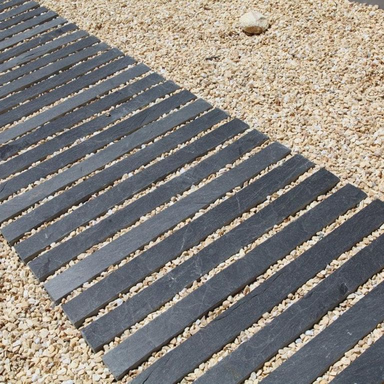 Application image for Slate - Iberian Gray - Pavers. The image shows this product being used in a path pavers application. Dominant colors shown are black and gray.