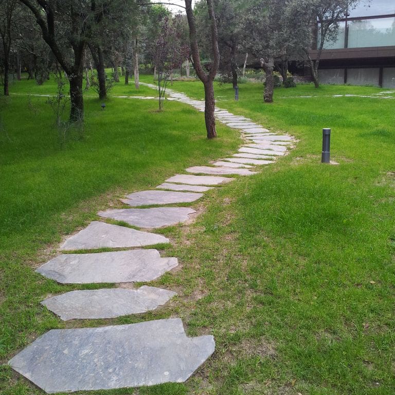 Application image for Slate - Iberian Gray - Pavers. The image shows this product being used in a path pavers application. The dominant color shown is gray. The color mix creates a warm feeling.