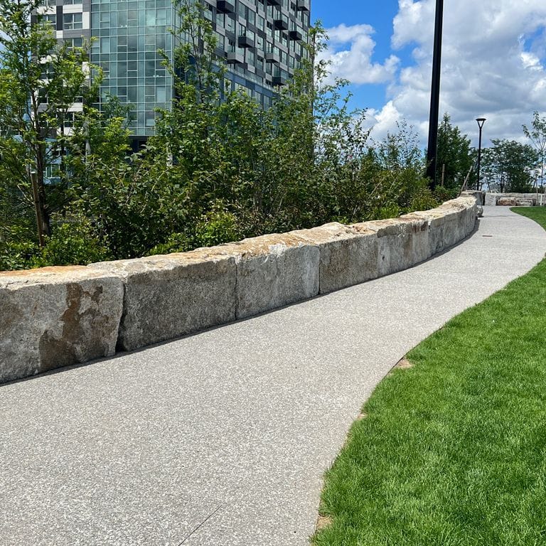 Application image for Reclaimed Granite Block - Seating Walls. The image shows this product being used for seating &amp; benches and landscape curbing &amp; edging. The dominant color shown is gray.
