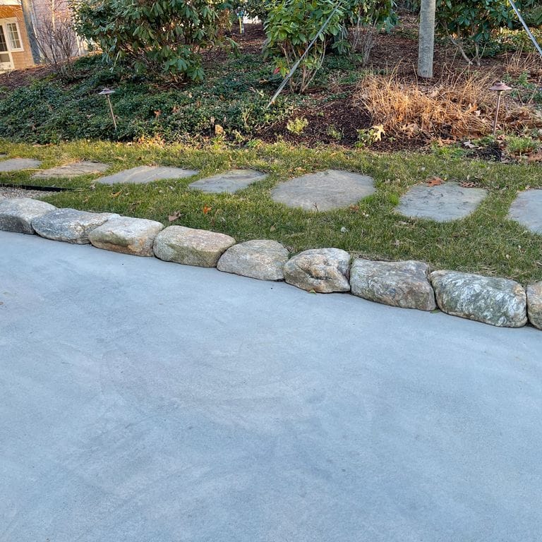 Application image for Fieldstone - New England Rounds - Edging . The image shows this product being used in a landscape curbing &amp; edging application. The surface finish shown is . The dominant color shown is gray. The color mix creates a cool feeling.
