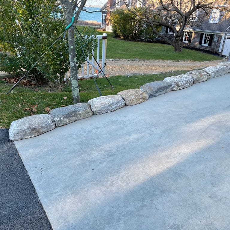 Application image for Fieldstone - New England Rounds - Edging . The image shows this product being used in a landscape curbing &amp; edging application. The surface finish shown is . The dominant color shown is gray. The color mix creates a cool feeling.