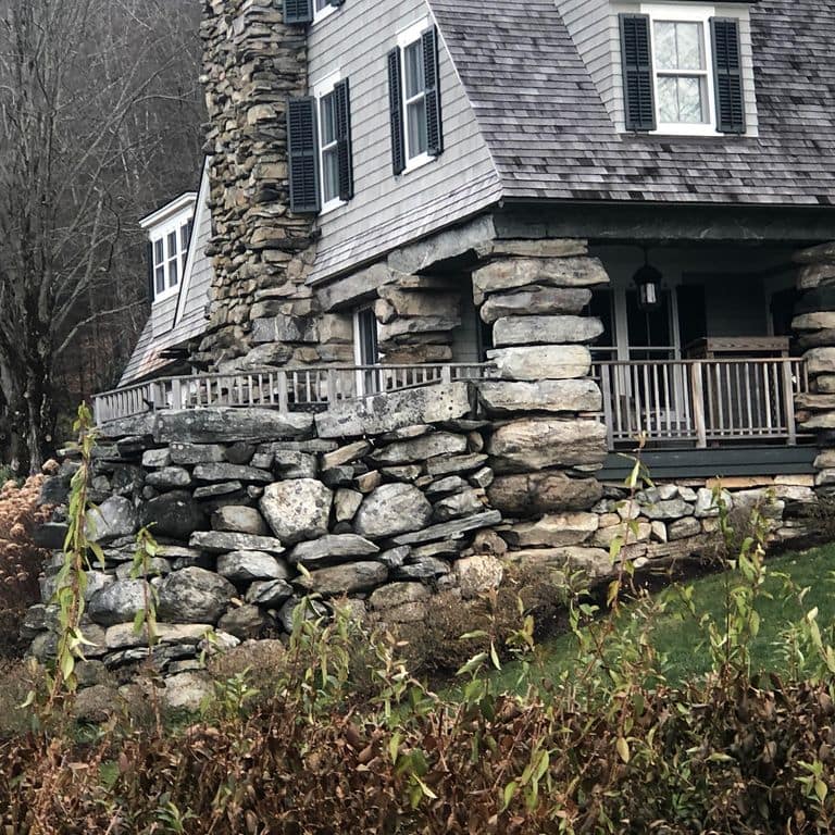 Application image for New England Fieldstone Mix - Veneer. The image shows this product being used in a full bed veneer application. The surface finish shown is weathered. The dominant color shown is gray. The color mix creates a cool feeling.