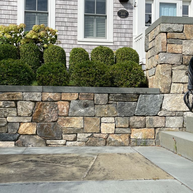 Application image for New England Fieldstone Mix - Veneer. The image shows this product being used in a thin veneer application. The surface finish shown is weathered. The dominant color shown is gray. The color mix creates a warm feeling.