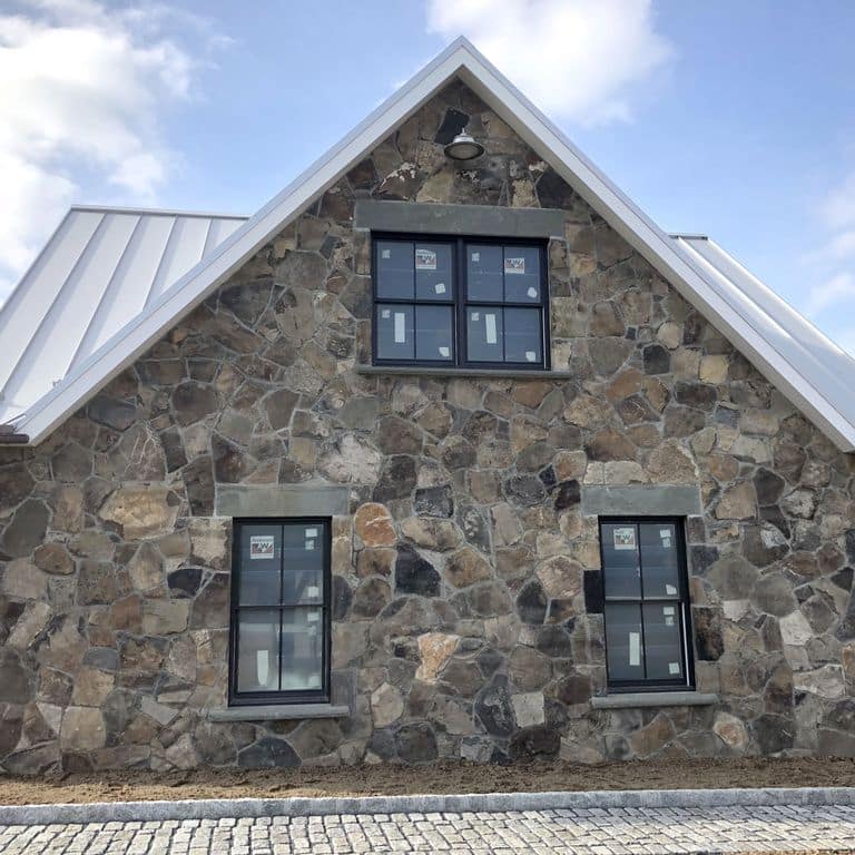 Application image for Fieldstone - Pennsylvania - Veneer. The image shows this product being used in a full bed veneer application. Dominant colors shown are gray and tan.