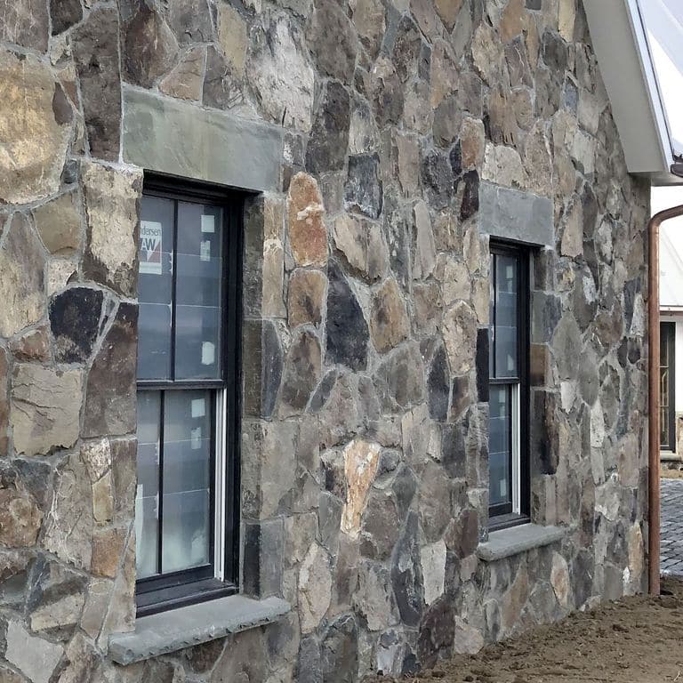 Application image for Fieldstone - Pennsylvania - Veneer. The image shows this product being used in a full bed veneer application. Dominant colors shown are gray and tan.