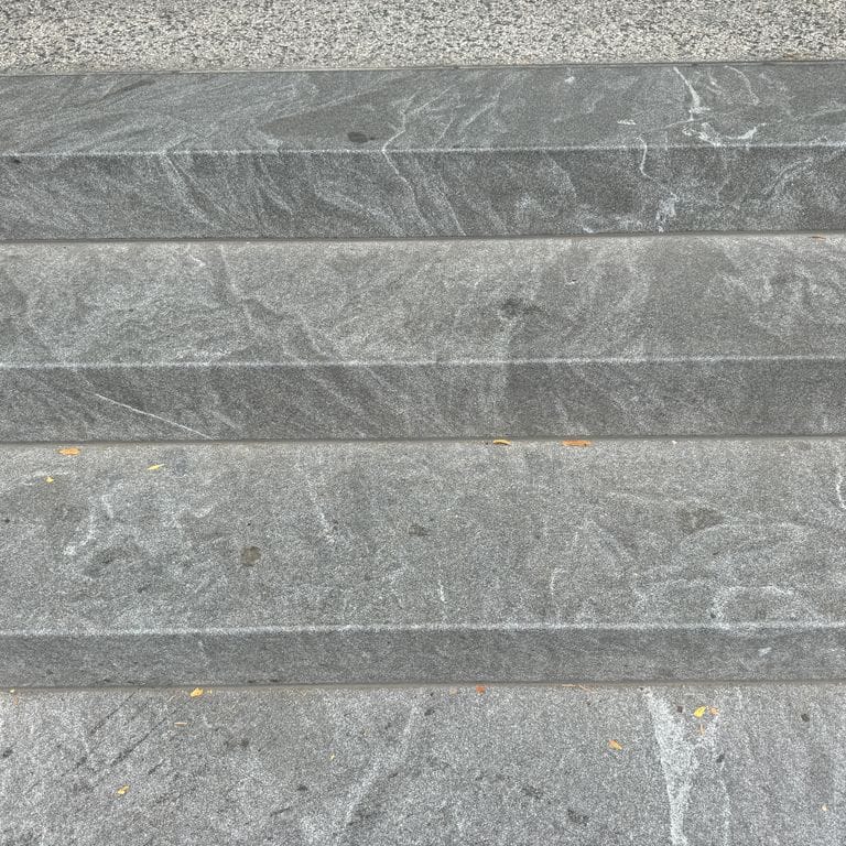 Application image for Granite - Jet Mist - Steps and Treads. The image shows this product being used in a monolithic steps application. The dominant color shown is gray. The color mix creates a warm feeling.