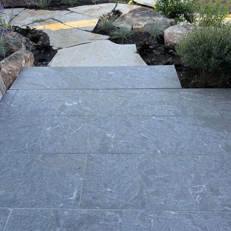 Application image for Granite - Jet Mist - Pavers. The image shows this product being used in a path pavers application. The dominant color shown is gray. The color mix creates a warm feeling.